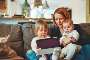 mom and young children looking at tablet