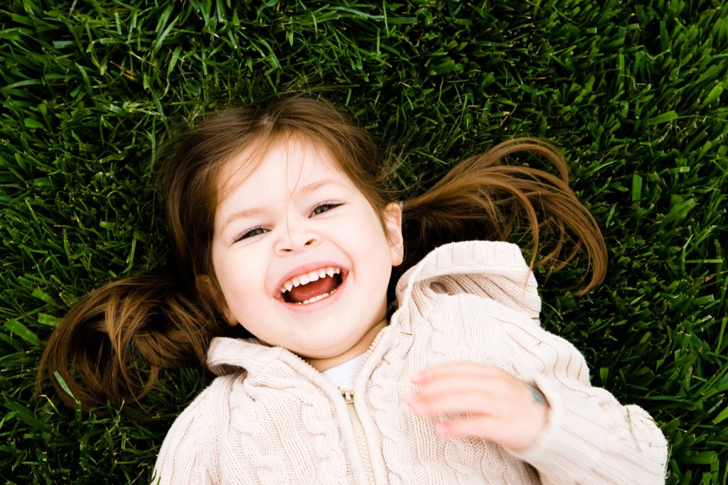 girl laughing in grass