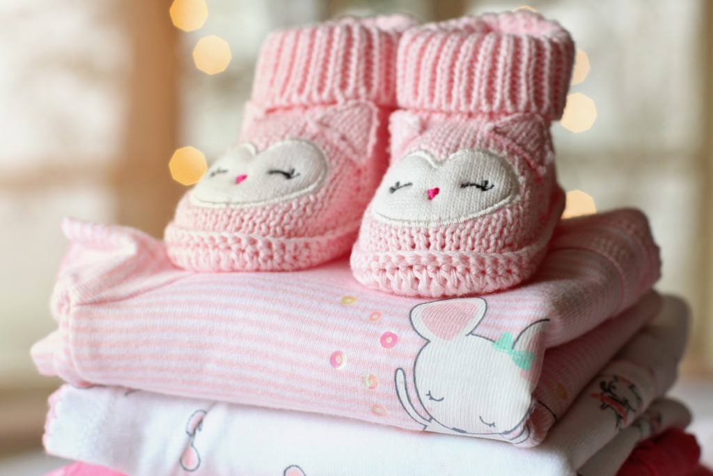 pink booties on folded clothes