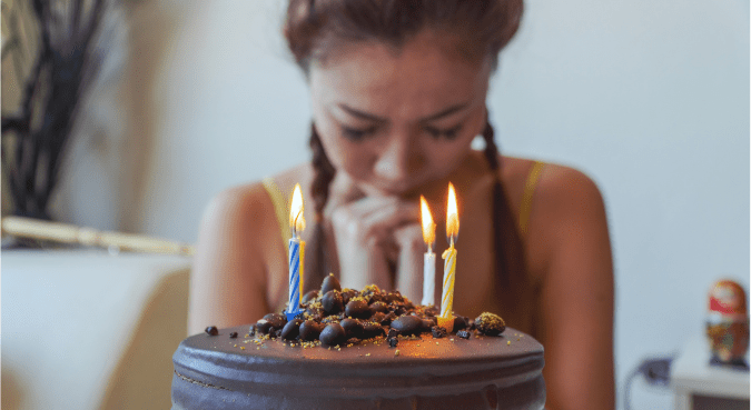 A teenage girl makes a wish before she blows out her candles.