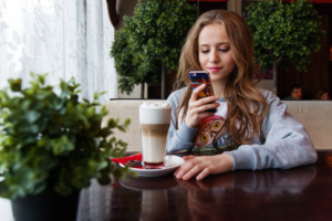 teen texting coffee shop