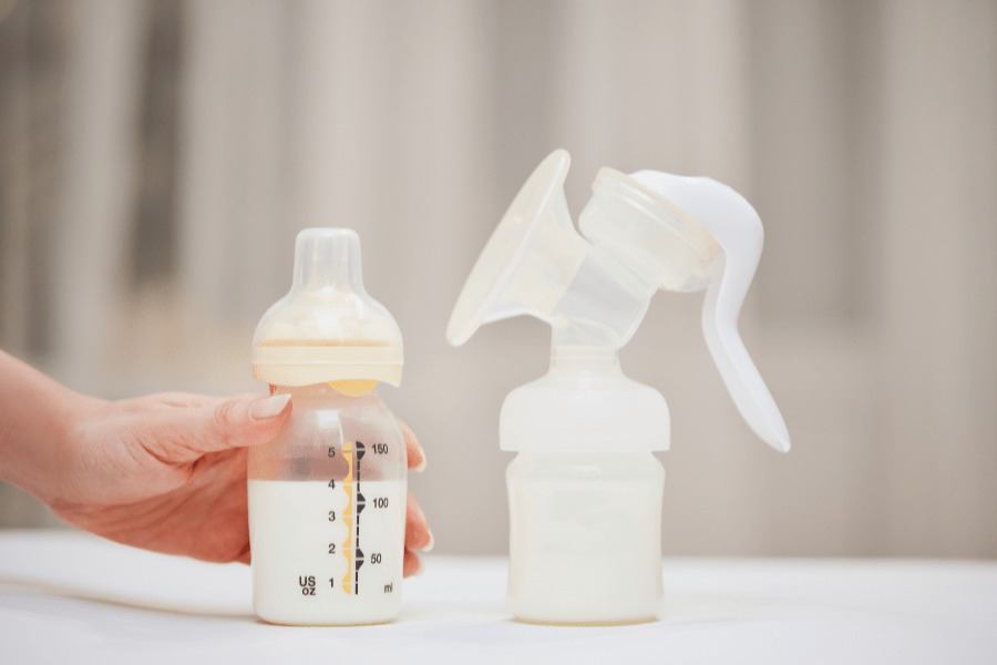 A bottle of breast milk is set next to a pumping bottle.