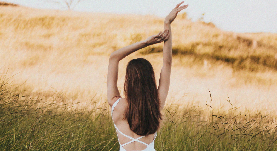 Woman raises arms in the air