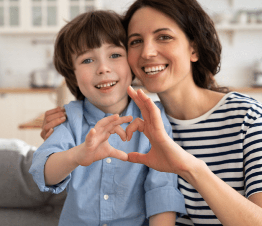 Mom and son make a heart with their hands