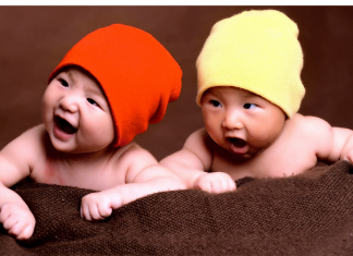 Happy twin babies wearing hats