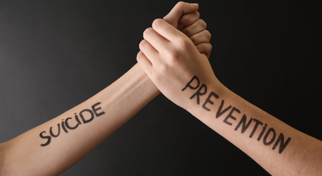 two arms locking hands that read "suicide prevention" 