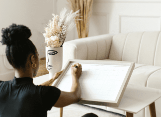 A woman write a calendar on a white board.
