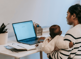 Mother and child sitting at computer working from home
