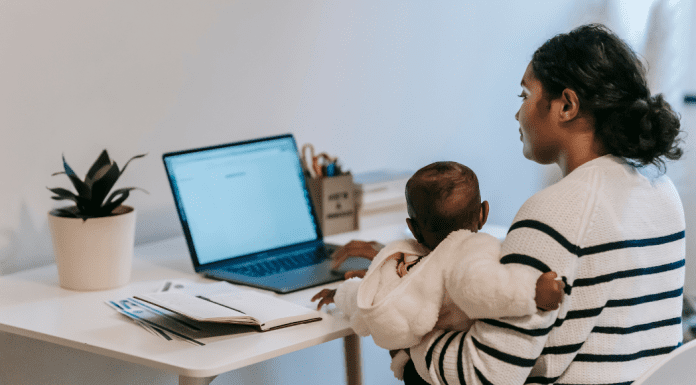Mother and child sitting at computer working from home