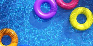 overhead view of a pool with colorful inner tubes