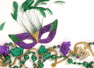 A mardi gras mask with feathers coming out the top.