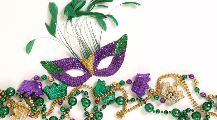 A mardi gras mask with feathers coming out the top.