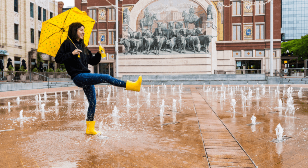 A girl splashes in Sundance Square.