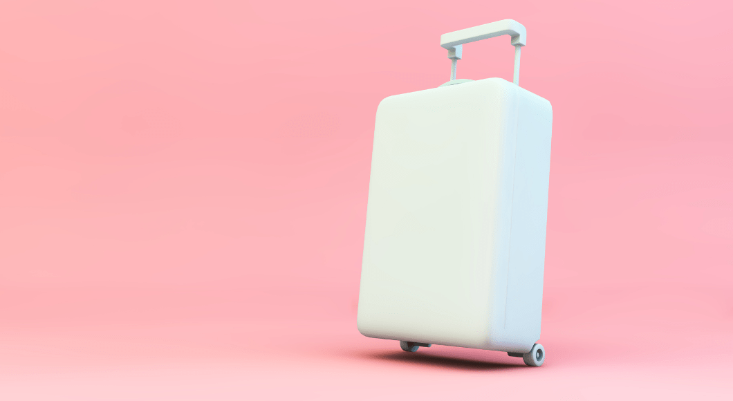 A white suitcase stands against a pink background.