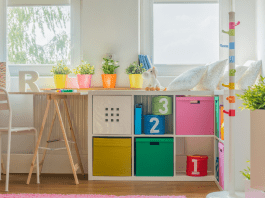 A child's organized room with a desk and bins.
