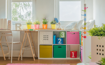 A child's organized room with a desk and bins.