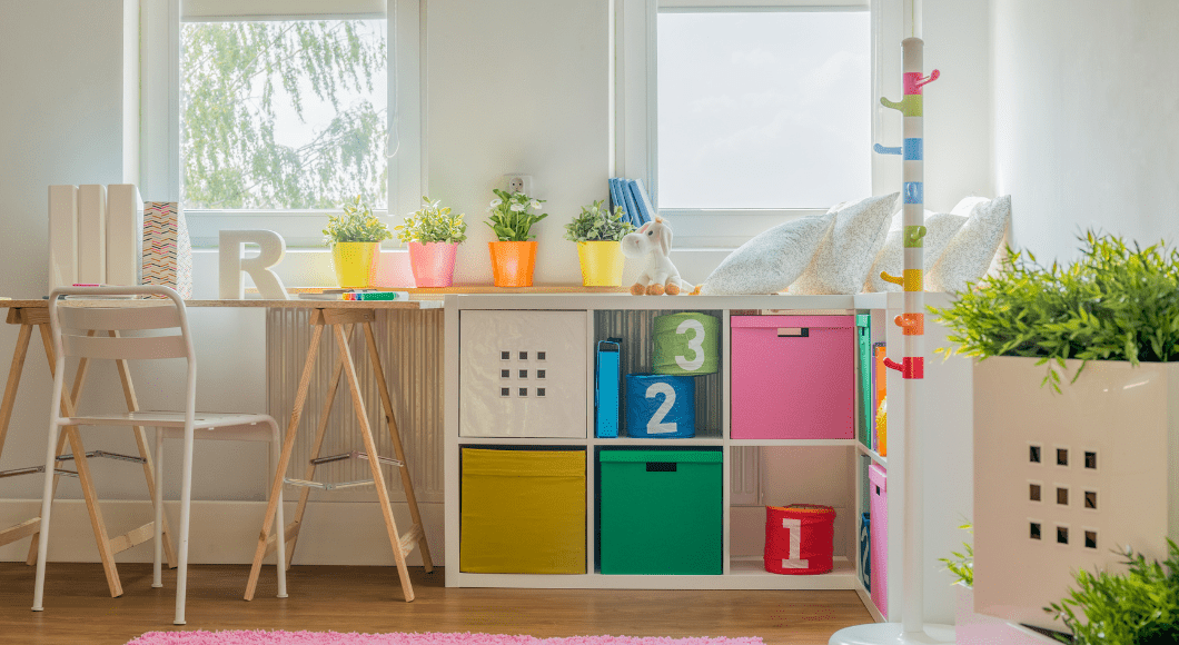 A child's organized room with a desk and bins.