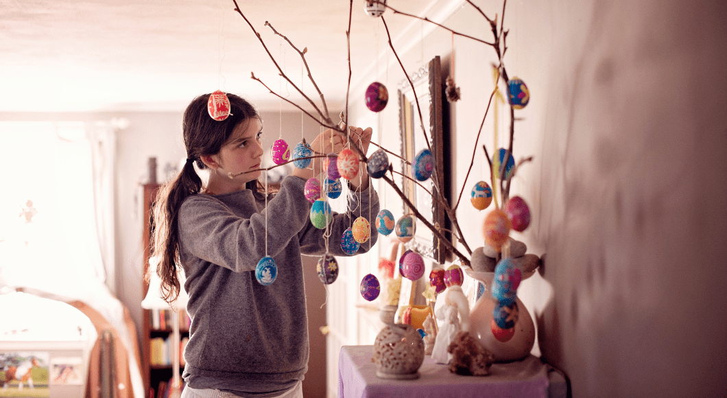 A young girl decorates an Easter tree.
