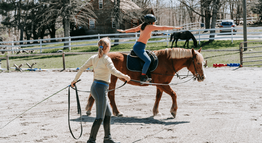 A girl takes a lesson on a horse.
