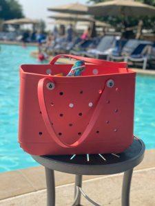 red bogg bag by a pool