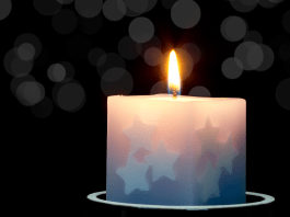 A candle with stars on it is lit.