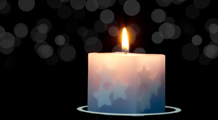 A candle with stars on it is lit.