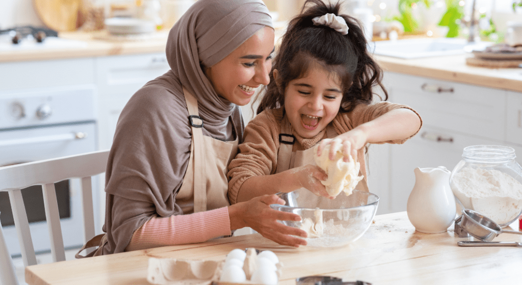 Mom and daughter enjoy making cookie dough together in the kitchen. 