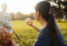 A mom playing baseball with her son in a field