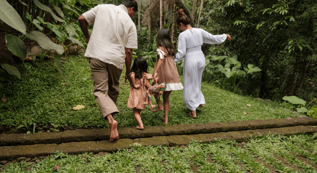 A family runs through a green garden barefoot on vacation 